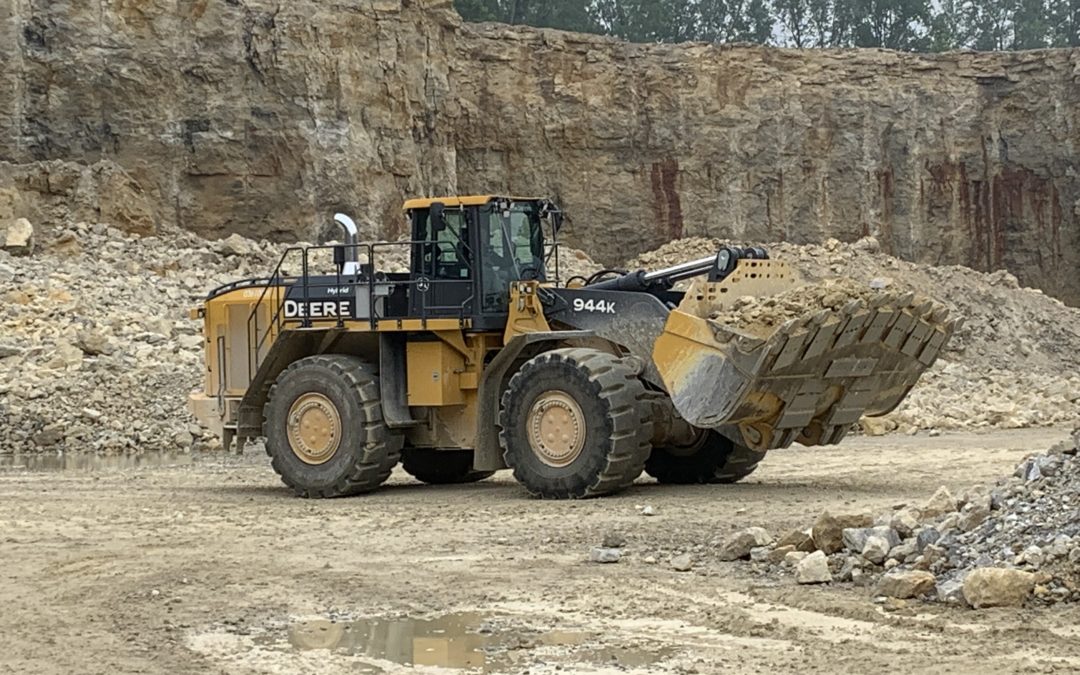 A John R. Jurgensen Company loader lifts rock in it's bucket to move it to another pile at a quarry owned by Melvin Stone Company.